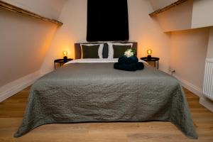 a bedroom with a bed with a gray blanket and two lamps at Luxury Rooms in Antwerp