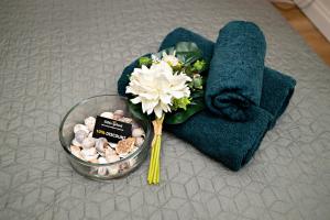a bouquet of flowers in a bowl next to towels at Luxury Rooms in Antwerp