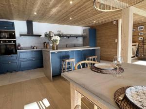 沙泰勒的住宿－3 FONTAINES - BELLAGIO E3 - BO IMMOBILIER CHATEL，厨房配有蓝色橱柜和桌椅