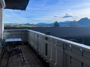 a balcony with a table and a view of a roof at Wildgrün in Pfronten