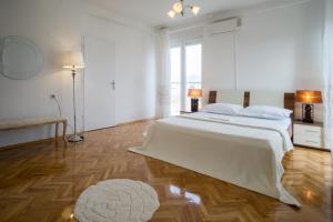 een witte slaapkamer met een groot bed en een tapijt bij Jelena Apartment in Split