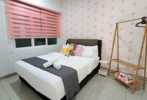 a bedroom with a bed with a teddy bear on it at IPOH CITY CENTRE Majestic Homestay Pool View 3 mins Walking to Famous Food Places by Happy Homestay in Ipoh