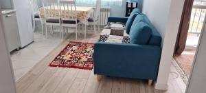 a blue couch in a living room with a rug at ЖК PRESIDENT в 5 мин от моря in Aktau