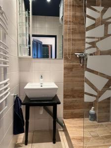 łazienka z umywalką i lustrem w obiekcie Apartament - Nowoczesny i Stylowy w Bydgoszczy