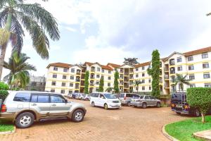 un estacionamiento con autos estacionados frente a un edificio en Willington Haven, en Kampala
