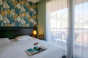 a bedroom with a bed with a book on it at ibis Styles Beaulieu sur Mer in Beaulieu-sur-Mer +37 photos