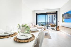 a white living room with a table and chairs at Sunset Waves 3-194 Poniente Beach Resort in Benidorm