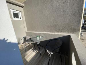 Elle comprend un petit balcon avec une table et des chaises. dans l'établissement Costa Paradise Beach, à Costa da Caparica