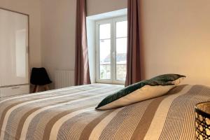 Schlafzimmer mit einem Bett und einem Fenster in der Unterkunft Appartement confortable proche des commodités in Moncel-lès-Lunéville