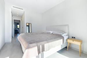 um quarto branco com uma cama grande e uma mesa em Sunset Waves 3-194 Poniente Beach Resort em Benidorm