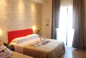 A bed or beds in a room at Hotel Mimosa