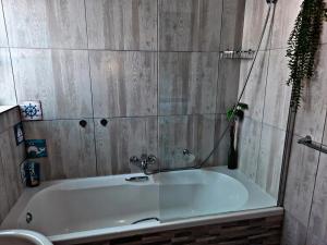 y baño con bañera y paredes de madera. en Feel@Home, en Ciudad del Cabo