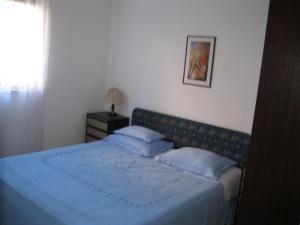 a bedroom with a blue bed with blue sheets and pillows at Apartments Maria in Supetar