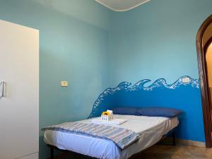 a blue bedroom with a bed with a blue wall at La Perugina in Gallipoli