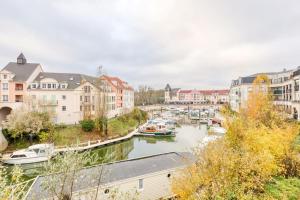 uitzicht op een rivier in een stad met boten bij STUDIO VUE DIRECT SUR LE PORT DE CERGY, Parking Privé Gratuit in Cergy