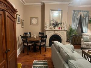 ein Wohnzimmer mit einem Sofa und einem Tisch in der Unterkunft 1 Br Private Victorian Apt in convenient City location on 5 acre, sleeps 4 in Poughkeepsie