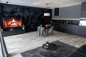 a living room with a fireplace and a table at BÚDA Jasná in Demanovska Dolina