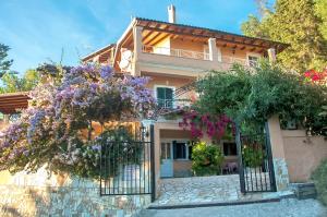 a house with flowers on the front of it at Holiday Studio Apartment Tonia - Pelekas Beach, Corfu in Pelekas