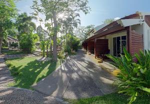 a house with a road next to a yard with trees at Sandhana Samet Resort in Ko Samed