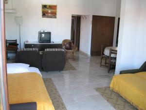 een woonkamer met 2 bedden en een televisie bij Apartments Maria in Supetar