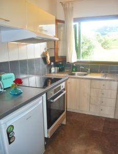 uma cozinha com pia e fogão forno superior em House Angelos D with sea view and private garden - Agios Gordios Beach em Agios Gordios