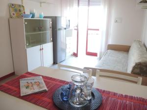 a kitchen with a table with a book on a table sidx sidx sidx at Renewed two-roomed flat with swimming pool in Bibione