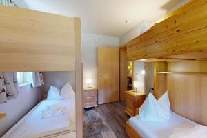 two bunk beds in a room with wooden floors at Ski in Ski Out neu und gehoben in Saalbach-Hinterglemm