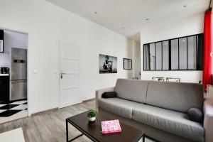 a living room with a couch and a table at CMG Republique - Montorgueil - Vertbois II in Paris