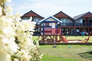 a house with a playground in front of it at Resort Mielenko in Mielenko
