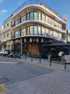 a building on a street with benches in front of it at Danezis City Stars Boutique Aparthotel in Rhodes Town