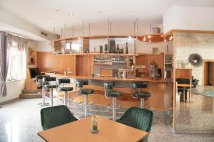 a restaurant with a bar with chairs and tables at Fairway Hotel in Sankt Leon-Rot