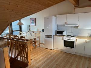 a kitchen with white appliances and a table with chairs at Fagertoppen 6B in Trysil