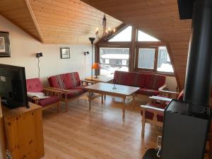 a living room with red couches and a table at Fagertoppen 6B in Trysil