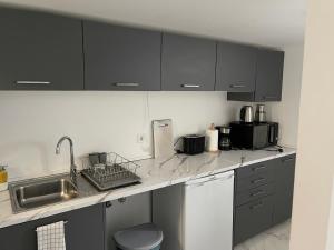 a kitchen with black cabinets and a sink at Costa Paradise Beach in Costa da Caparica