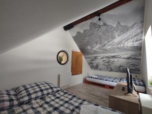 um quarto com uma cama e um quadro na parede em Chata nad potokem em Belá pod Pradedem