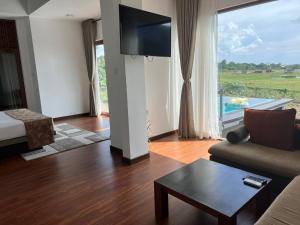 a living room with a couch and a large window at Blue Wild - Yala - Plastic Free & Sustainable in Tissamaharama