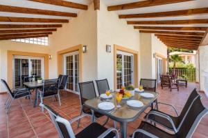 a patio with a table and chairs on a patio at Villa Dorada - PlusHolidays in Calpe