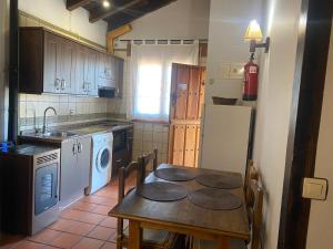 a kitchen with a table and a sink and a dishwasher at Posadas De Granadilla in Zarza de Granadilla
