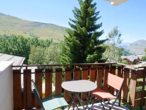 a table and chairs on a balcony with a tree at appartement ski au pied in Les Deux Alpes