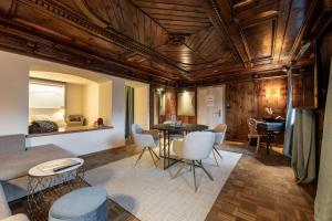 een woonkamer met houten plafonds en een tafel en stoelen bij Hotel Wirtshaus Post in Sankt Johann in Tirol