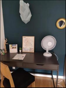 una scrivania con lampada e un ventilatore di Charmant appartement lumineux à Reims a Reims