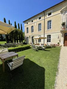 un bâtiment avec une table et des chaises dans une cour dans l'établissement Chateau Talaud, à Loriol-du-Comtat