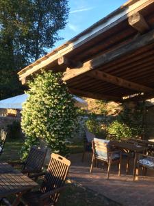 un patio con mesa y sillas bajo un techo de madera en Residenzia Del Sogno, en Castellina in Chianti