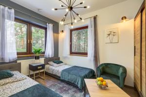 a bedroom with two beds and a table with a bowl of fruit at Leśna Rezydencja in Łabowa