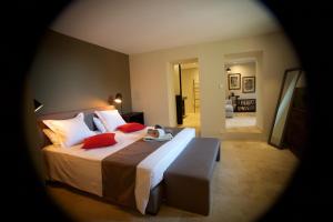 um quarto com uma cama grande e almofadas vermelhas em Chambres d'hôtes Le Pontillaou em La Garde-Freinet