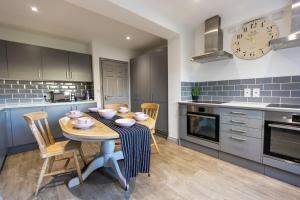 7 Bed House Pitchford Road في Earlham: مطبخ مع طاولة وكراسي في غرفة