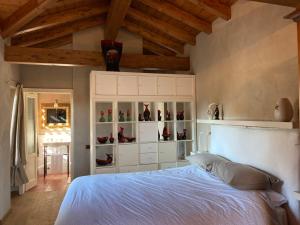 Un dormitorio con una cama blanca con zapatos en un armario en Casetta Camilla, en Varese