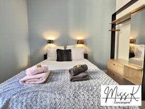 a bedroom with a bed with towels on it at L'Eden de Miss.K Conciergerie in Châtillon-sur-Chalaronne