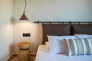 コス・タウンにあるAnastasia Hotel & Apartmentsのベッドルーム1室(白い枕とテーブル付)