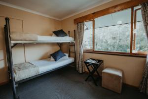 a bedroom with two bunk beds and a window at Tsitsikamma Backpackers in Stormsrivier